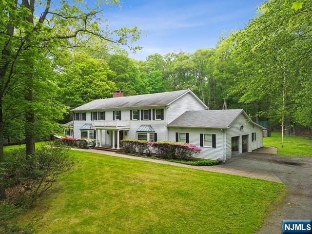 75 Woodcliff Lake Rd, Saddle River, NJ 07458 - colonial-style house with a balcony, a chimney, a front lawn, driveway, and a garage