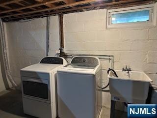 laundry area featuring washing machine and dryer and concrete block wall