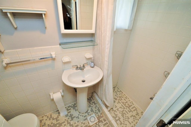 79 Arthur St, Ridgefield Park, NJ 07660 - bathroom featuring tile walls, a stall shower, toilet, and a sink