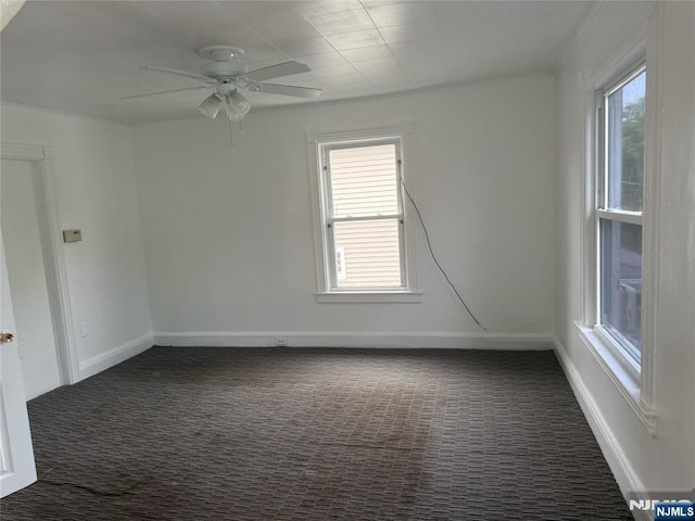 spare room with carpet, a ceiling fan, and baseboards