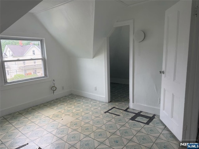 additional living space with lofted ceiling and baseboards