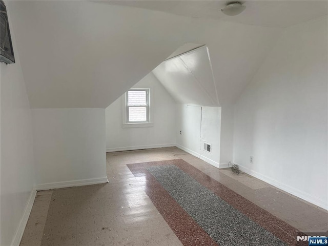 bonus room with baseboards and vaulted ceiling
