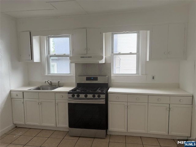 kitchen featuring gas range, under cabinet range hood, a sink, white cabinets, and light countertops