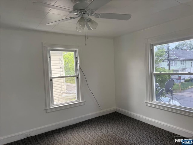 spare room with ceiling fan, baseboards, and carpet flooring