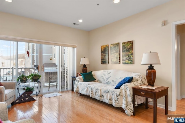 living area featuring hardwood / wood-style floors, recessed lighting, and baseboards