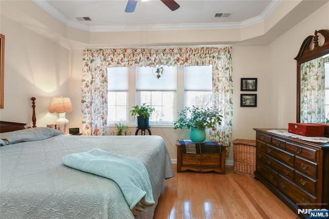 bedroom with light wood finished floors, crown molding, ceiling fan, and baseboards