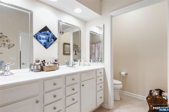 full bathroom featuring tile patterned flooring, toilet, double vanity, and baseboards