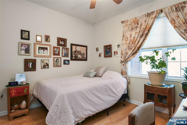 bedroom featuring wood finished floors, baseboards, and a ceiling fan