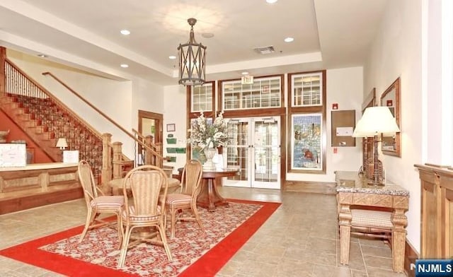 dining area with recessed lighting, stairway, a raised ceiling, a towering ceiling, and a chandelier