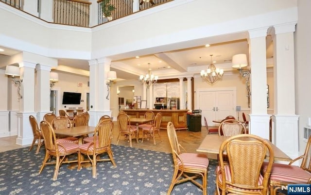 dining space with decorative columns, a decorative wall, a chandelier, a wainscoted wall, and crown molding