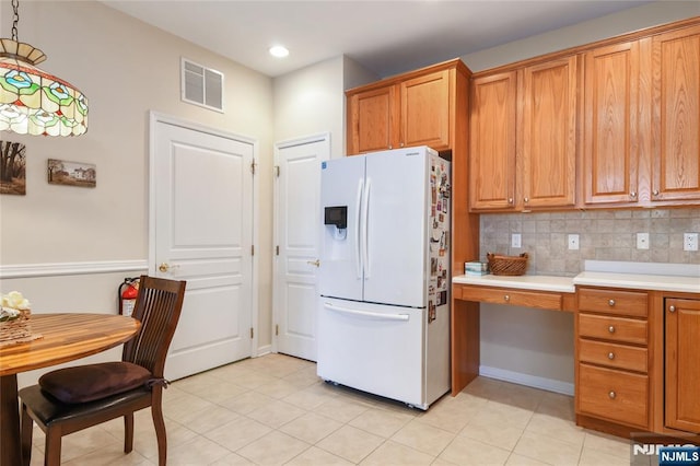 kitchen with white fridge with ice dispenser, recessed lighting, brown cabinetry, light countertops, and light tile patterned floors