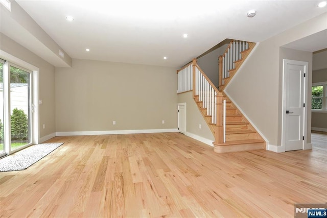 14 Charles Ter, Waldwick, NJ 07463 - unfurnished living room featuring healthy amount of natural light, stairway, baseboards, light wood-style floors, and recessed lighting