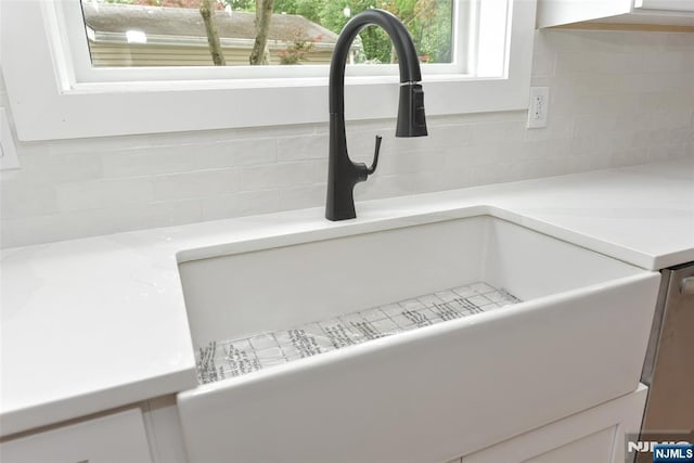 14 Charles Ter, Waldwick, NJ 07463 - kitchen view of a sink, backsplash, white cabinetry, and light countertops
