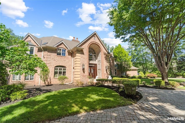 14 Stewart Ct, Old Tappan, NJ 07675 - view of front of home with brick siding, a front yard, and a chimney