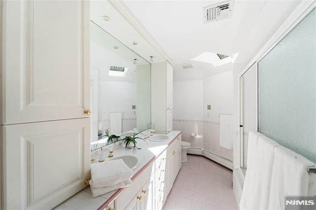 14 Stewart Ct, Old Tappan, NJ 07675 - bathroom with a baseboard heating unit, toilet, a skylight, double vanity, and tile patterned floors