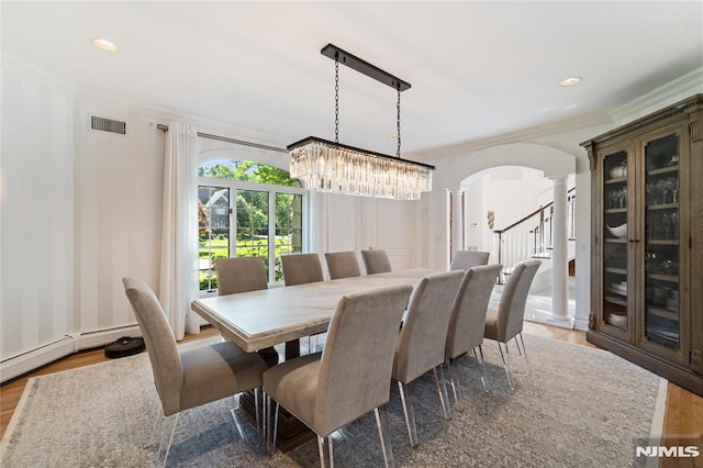 14 Stewart Ct, Old Tappan, NJ 07675 - dining area with decorative columns, ornamental molding, arched walkways, wood finished floors, and a chandelier