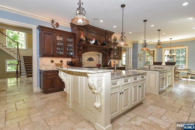 70 Oak Dr, Upper Saddle River, NJ 07458 - kitchen with a center island with sink, stone tile flooring, backsplash, recessed lighting, and glass insert cabinets