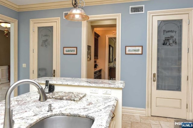 70 Oak Dr, Upper Saddle River, NJ 07458 - kitchen with a sink, light stone finish flooring, crown molding, decorative light fixtures, and baseboards