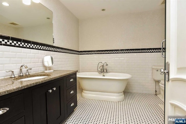70 Oak Dr, Upper Saddle River, NJ 07458 - full bath featuring tile walls, vanity, a soaking tub, and a wainscoted wall