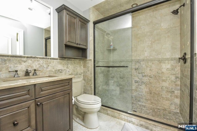70 Oak Dr, Upper Saddle River, NJ 07458 - bathroom featuring vanity, toilet, a tile shower, tile walls, and tile patterned floors