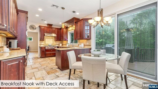 108 Buckhaven Hl, Upper Saddle River, NJ 07458 - kitchen featuring under cabinet range hood, stone tile flooring, decorative backsplash, hanging light fixtures, and stainless steel gas stovetop