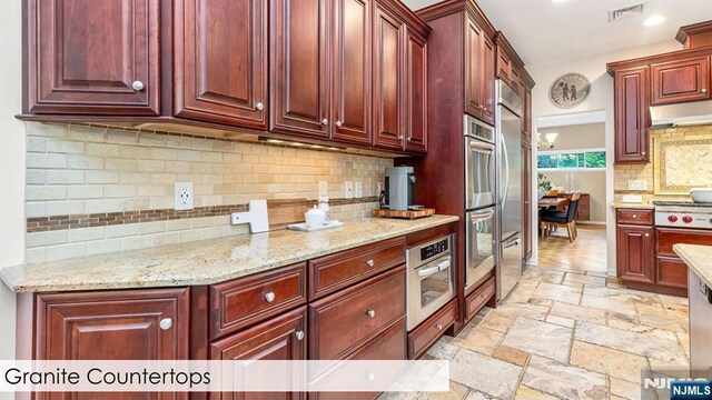 108 Buckhaven Hl, Upper Saddle River, NJ 07458 - kitchen with dark brown cabinets, stone tile flooring, appliances with stainless steel finishes, and tasteful backsplash