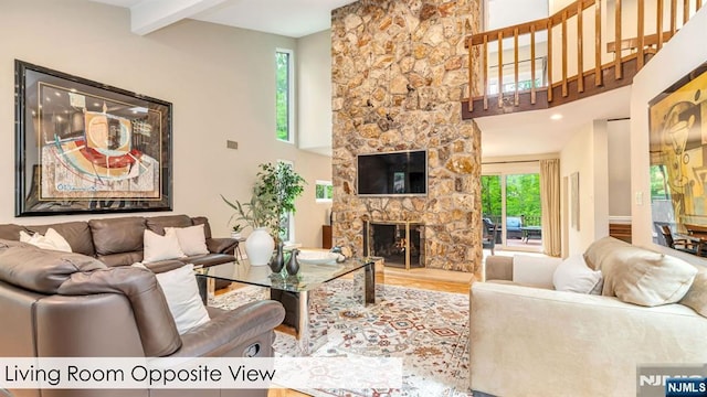 108 Buckhaven Hl, Upper Saddle River, NJ 07458 - living room featuring plenty of natural light, a stone fireplace, wood finished floors, beam ceiling, and a high ceiling