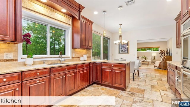108 Buckhaven Hl, Upper Saddle River, NJ 07458 - kitchen with a sink, stone tile floors, a chandelier, backsplash, and hanging light fixtures