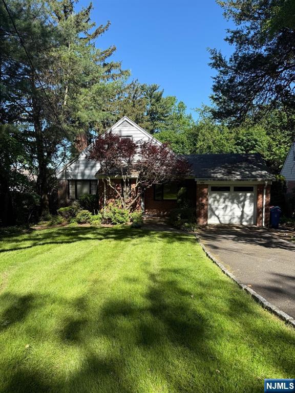 384 Audubon Rd, Englewood, NJ 07631 - view of front of property featuring asphalt driveway, an attached garage, a front yard, and brick siding