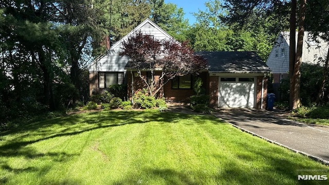 384 Audubon Rd, Englewood, NJ 07631 - view of front of house with a garage, driveway, brick siding, and a front lawn