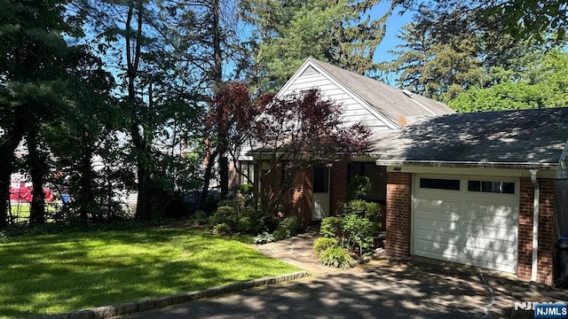 384 Audubon Rd, Englewood, NJ 07631 - view of front of house featuring a garage, brick siding, asphalt driveway, and a front lawn