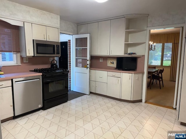 384 Audubon Rd, Englewood, NJ 07631 - kitchen with stainless steel appliances, plenty of natural light, a chandelier, and open shelves