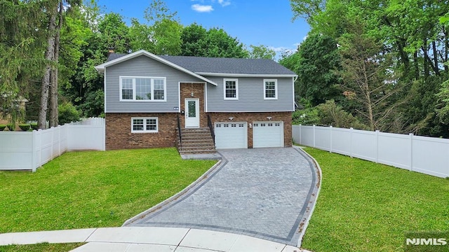 split foyer home featuring brick siding, an attached garage, decorative driveway, and a chimney