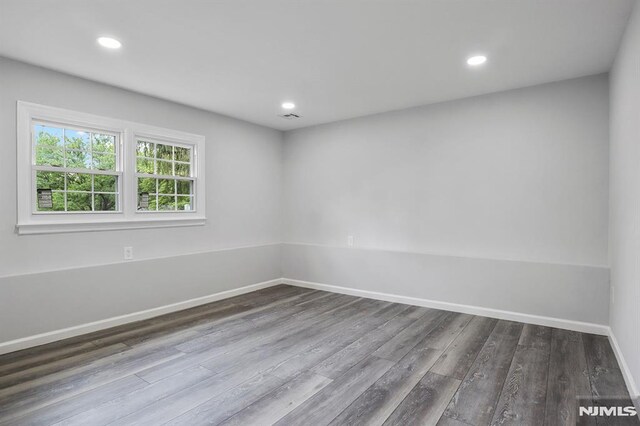 empty room featuring dark wood-style floors, recessed lighting, and baseboards