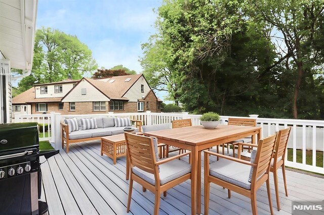 wooden deck featuring area for grilling, outdoor dining area, and an outdoor living space
