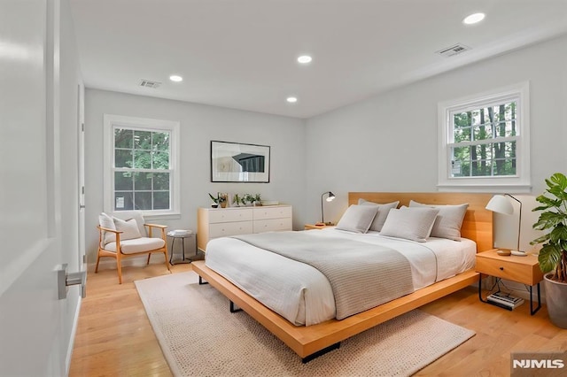 bedroom with light wood finished floors and recessed lighting