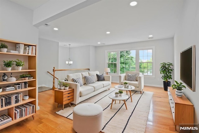 living area featuring light wood finished floors, recessed lighting, and a chandelier