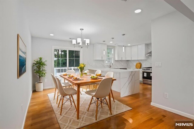 dining room with recessed lighting, light wood-style flooring, a chandelier, and baseboards
