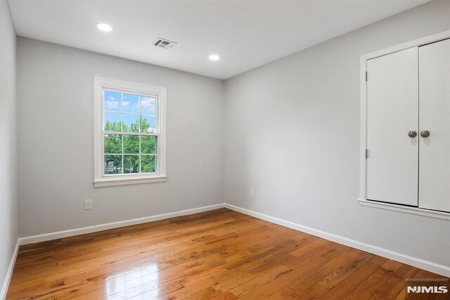 empty room featuring light wood-style floors, baseboards, and recessed lighting