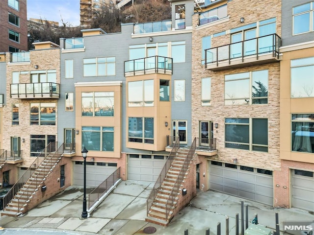 8709 Churchill Rd, North Bergen, NJ 07047 - view of apartment building / complex with a garage, stairs, and driveway