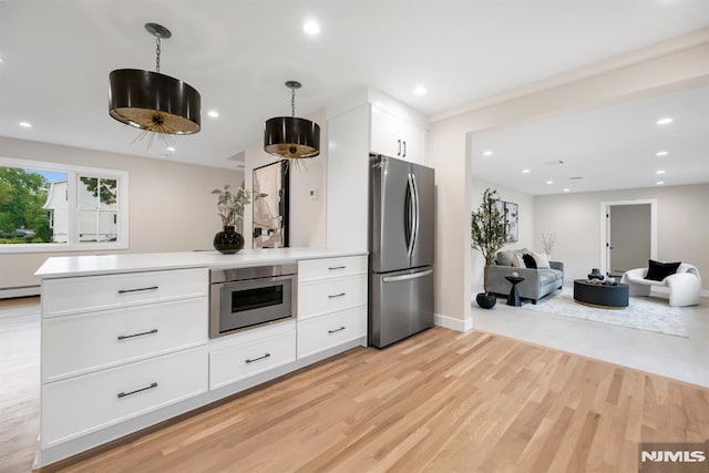 246 Oakwood Dr, Paramus, NJ 07652 - kitchen featuring appliances with stainless steel finishes, white cabinets, open floor plan, light countertops, and light wood finished floors