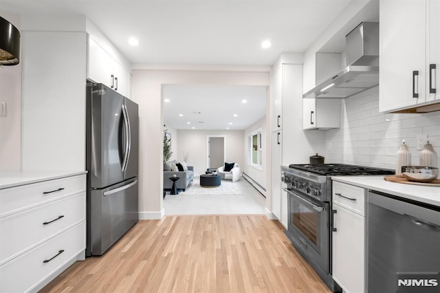 246 Oakwood Dr, Paramus, NJ 07652 - kitchen with stainless steel appliances, wall chimney exhaust hood, decorative backsplash, white cabinets, and light wood finished floors