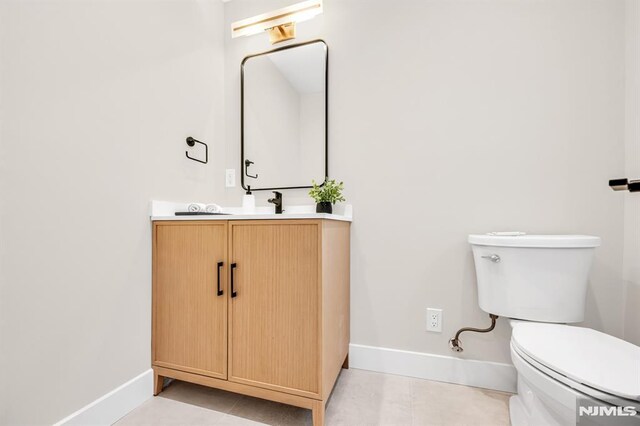 246 Oakwood Dr, Paramus, NJ 07652 - bathroom with baseboards, toilet, vanity, and tile patterned floors