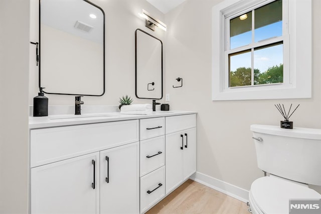 246 Oakwood Dr, Paramus, NJ 07652 - bathroom with baseboards, toilet, double vanity, and wood finished floors