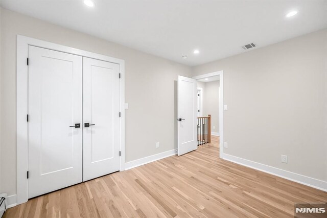 246 Oakwood Dr, Paramus, NJ 07652 - unfurnished bedroom featuring recessed lighting, light wood-style flooring, baseboards, a baseboard heating unit, and a closet