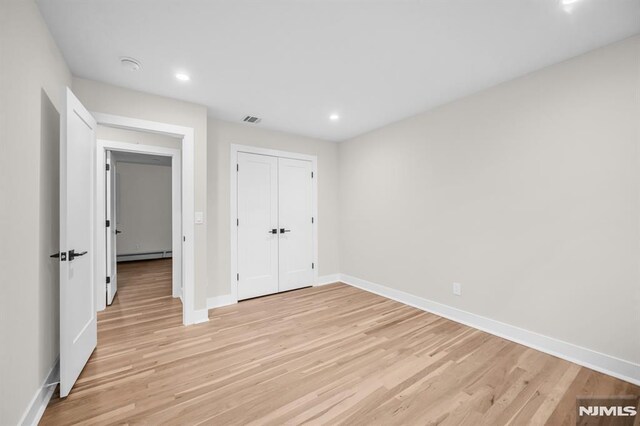 246 Oakwood Dr, Paramus, NJ 07652 - unfurnished bedroom with a baseboard radiator, light wood finished floors, baseboards, recessed lighting, and a closet