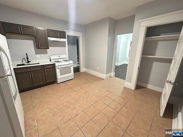 257 New St, Orange, NJ 07050 - kitchen featuring white appliances, a sink, light countertops, light tile patterned floors, and under cabinet range hood
