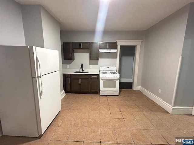 257 New St, Orange, NJ 07050 - kitchen with white appliances, under cabinet range hood, a sink, light countertops, and dark brown cabinets