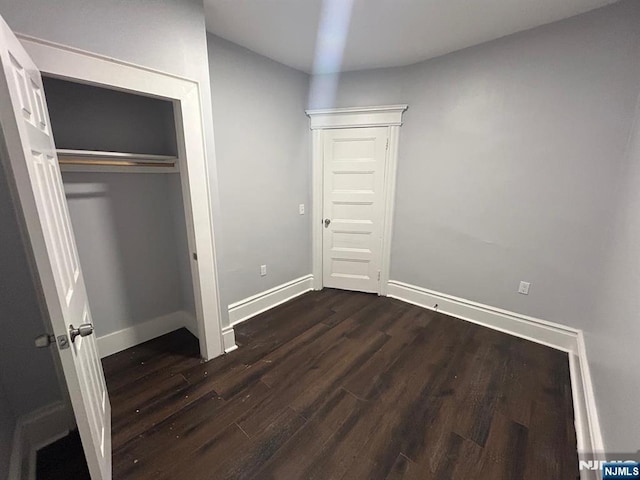257 New St, Orange, NJ 07050 - unfurnished bedroom featuring dark wood-style floors, baseboards, and a closet