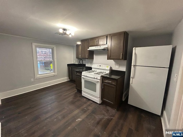 257 New St, Orange, NJ 07050 - kitchen with white appliances, under cabinet range hood, dark countertops, dark wood-type flooring, and a sink